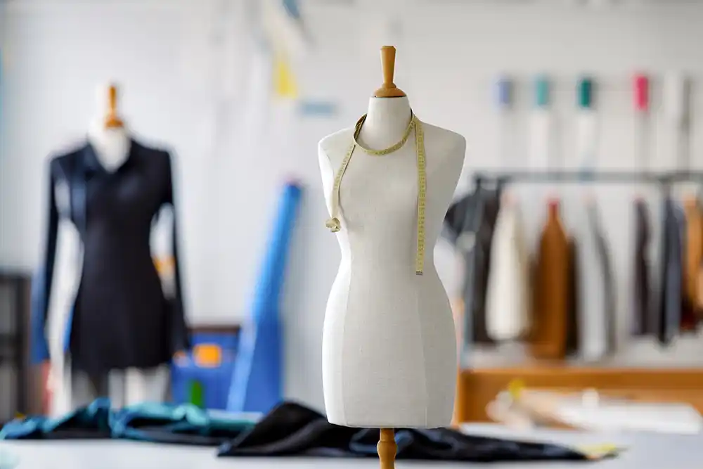 Schneiderpuppe mit Maßband, Werkstatt im Hintergrund